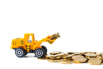 Mini bulldozer truck loading stack coin with pile of gold coin, isolated on white background with copy space, business finance and banking industrial concept.