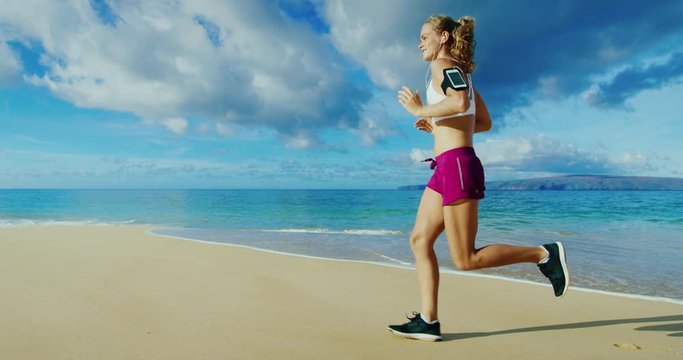 Athletic young woman running on the beach