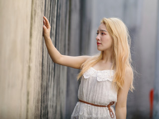 Fototapeta premium Beautiful Chinese young girl wearing a white dress in summer park. Outdoor fashion portrait of glamour young Chinese cheerful stylish lady. Emotions, people, beauty and lifestyle concept.