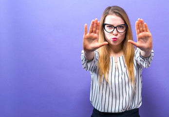 Young woman making a rejection pose on a solid background
