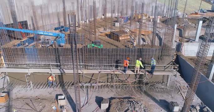 Aerial view from above of workers building a wall at a construction site