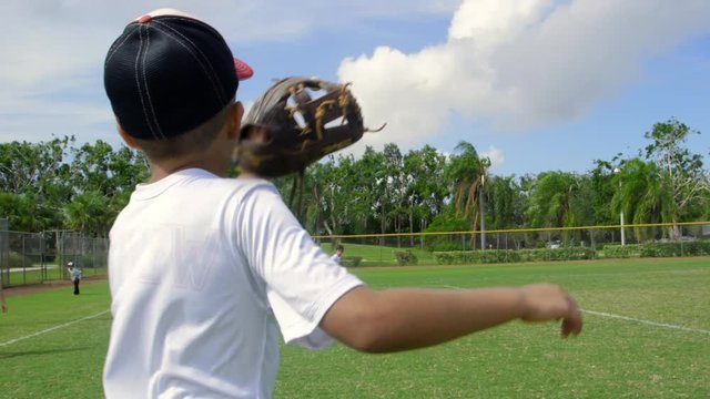 Slow motion of boy catching a ball during baseball practice