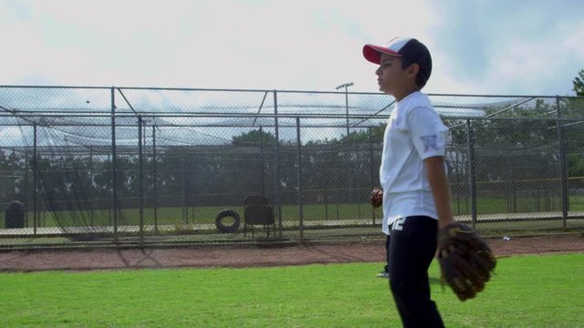 Cool slow motion of little boys catching and throwing ball at baseball park during practice