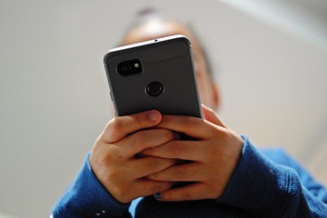 Young African American girl holds a smartphone