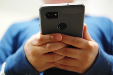 Young African American girl holds a smartphone