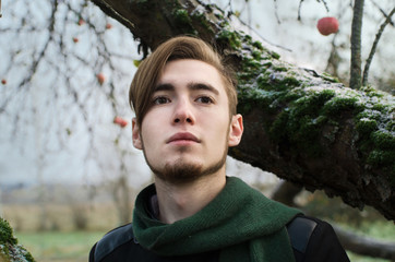 young boy around the curves of the trunks of trees