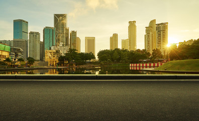 Fototapeta na wymiar Asphalt road side with beautiful Kuala Lumpur city waterfront skyline. Sunrise scene .