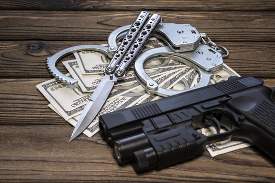 handcuffs gun knife and money dollars. Crime and punishment, criminal, theft. Armed attack.