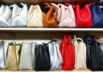 Collection of multi-colored women's handbags on the store shelfs. 