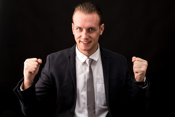 Successful businessman celebrating with arms up
