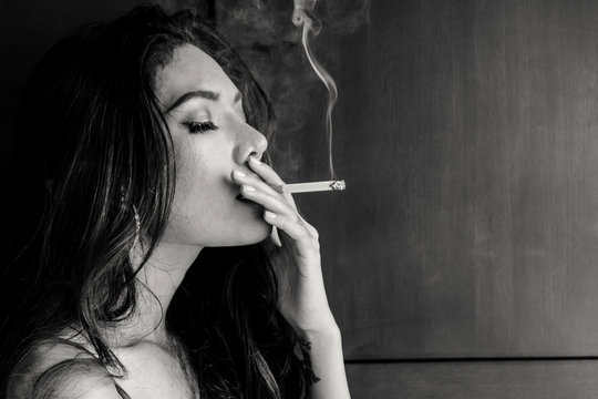 Fashion portrait of  beautiful woman sexy slim body smoking cigarette