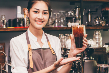 Woman barista giving coffee to customer at cafe