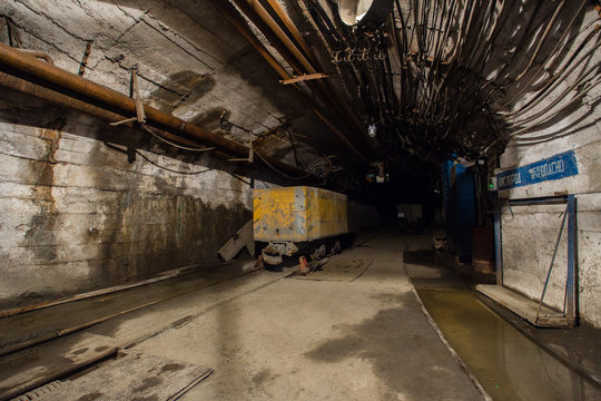Underground iron ore mine shaft tunnel gallery with ore cart wagon