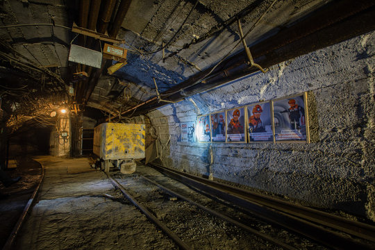 Underground iron ore mine shaft tunnel gallery with ore cart wagon