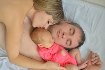 Fototapeta na wymiar The newborn girl fell asleep with her mother and father