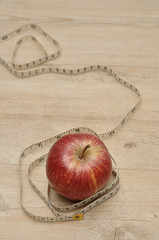A red apple displayed with a measuring tape