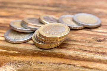 Euro coins on wooden table.