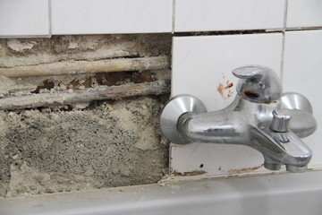 alter Wasserhahn mit kaputten Fliesen