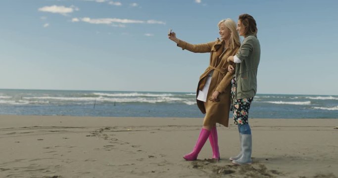 Girls having time and taking selfie on a beach