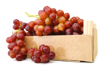 red grapes isolated in wooden crate on white