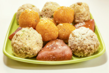 Different types of traditional Bengali Indian sweets in closeup view.