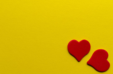  two paper red hearts on yellow background