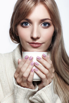 Blonde woman drinking a cap of tea