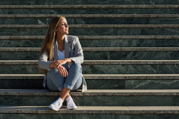 Beautiful young caucasian woman with eyes closed sitting on steps