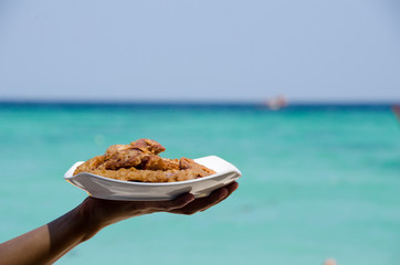 Fried banana in plate with woman hand ,seaside