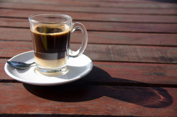 Close up Coffee cup on wood table and view of tropical beach.