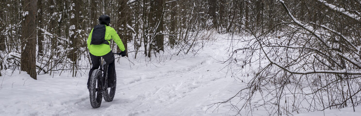Fat bike also called fat bike or fat-tire bike - Cycling on large wheels in the winter forest.