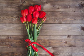 Spring flowers. Bouquet of Red tulips on brown wooden background.