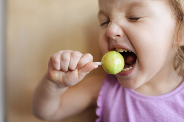 The girl eats big lollipop. The girl licks candy