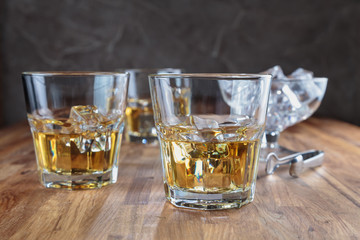 three glasses of whiskey on the oak surface of the table
