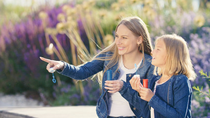 Happy mother and daughter with soap bubbles