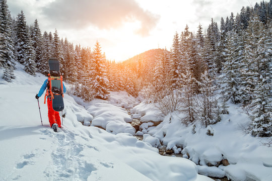 Snowboarder Walking On Snowshoes In Powder Snow.