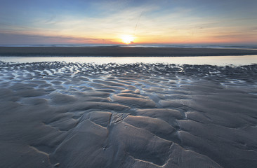 A beautiful sunset with great structures in the sand.