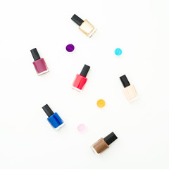 Obraz premium Bright nail polish on white background. Flat lay, top view. Beauty concept
