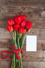 Spring flowers. Bouquet of Red tulips on brown wooden background.