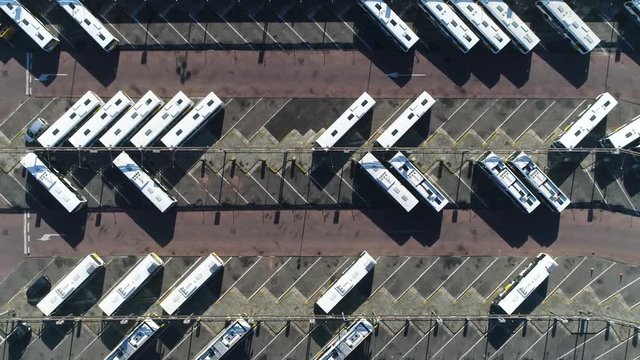 Aerial top down view of bus terminus is designated place where bus or coach starts or ends its scheduled route termini can be located at bus stations interchanges bus garages or bus stops 4k quality