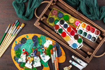 Fototapeta premium Paints for drawing and brush on a background in a composition