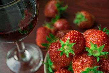 A glass of red wine and strawberries