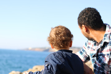 Father and son looking at the landscape of a cliff