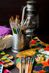 Paints for drawing and brush on a background in a composition