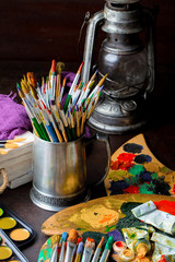 Paints for drawing and brush on a background in a composition