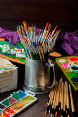 Paints for drawing and brush on a background in a composition