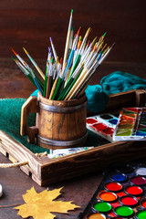 Paints for drawing and brush on a background in a composition