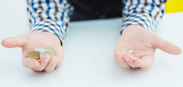 Boy's hands close-up: in one lies the tooth, in the second coins. First tooth lost.