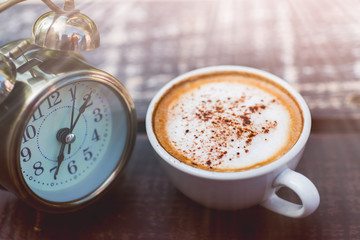 Coffee cappuccino in the morning and an alarm clock