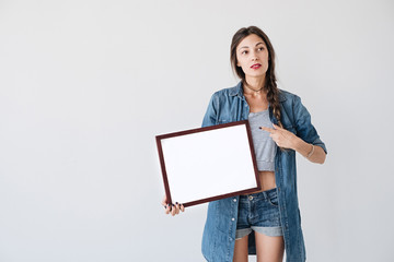 Girl showing to an empty frame